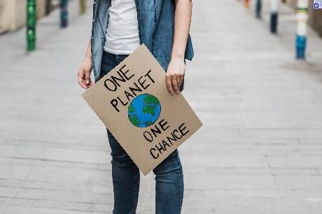 Person mit Schild One Planet One Chance
