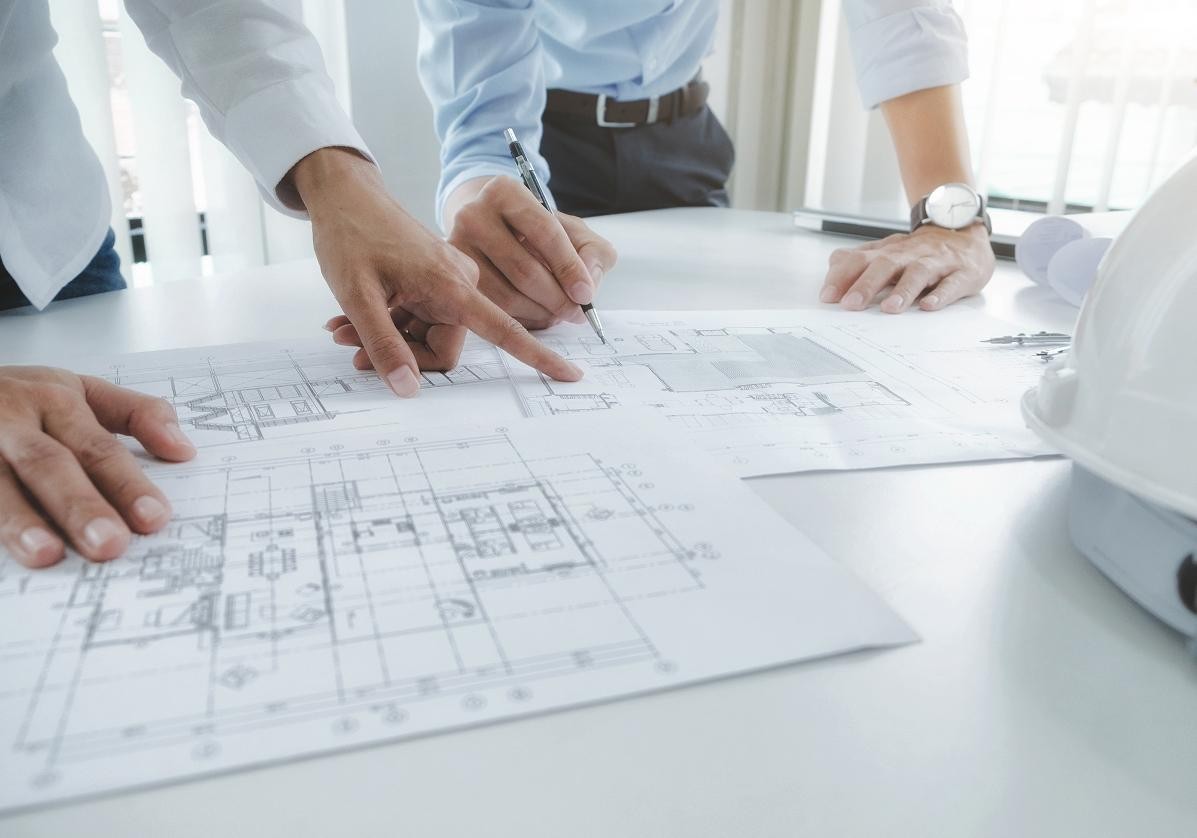 Zwei Personen mit Bauplänen Zwei Personen mit Bauplänen