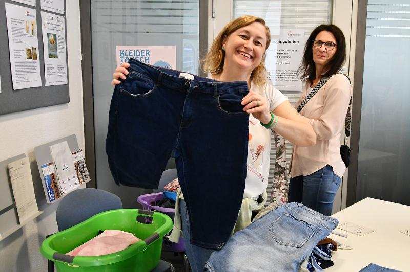 Zwei Personen beim Kleidertausch in der Volkshochschule